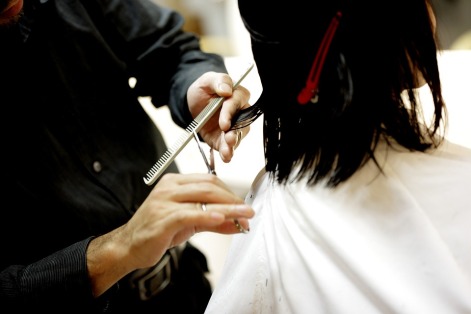 A girl getting her hair cut short and black